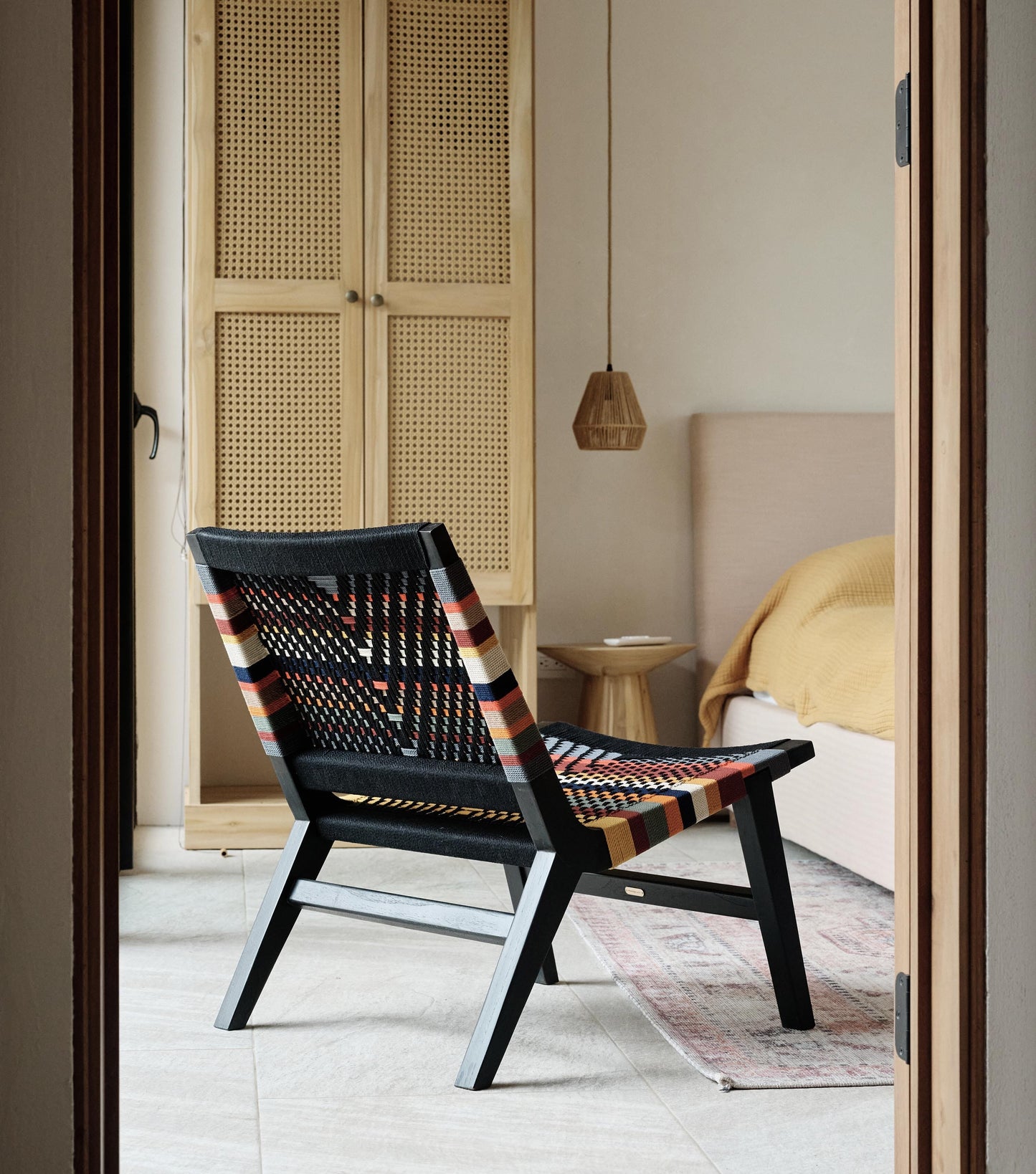 Artisan lounge chair featuring a woven seat and back with rich color detail 