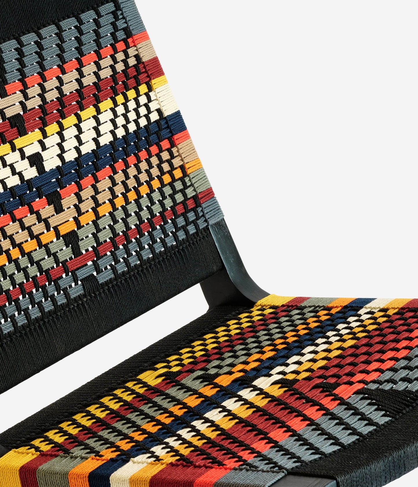 Black frame lounge chair with colorful woven pattern and low relaxed shape 