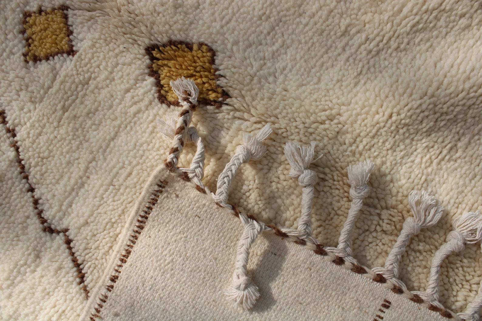 Brown zigzag Moroccan Berber rug handwoven on a natural ivory wool background