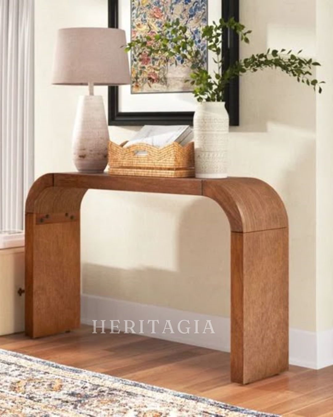 Curved console table in natural wood finish styled in a luxury entryway