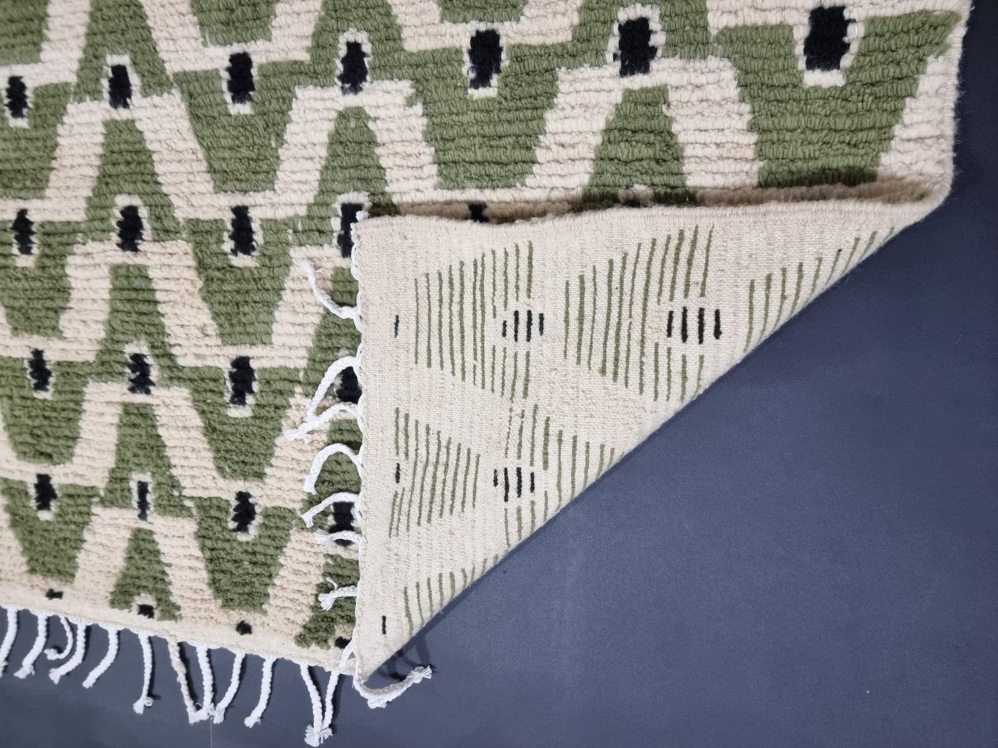 Green wool Beni Ourain rug featuring repeating geometric shapes