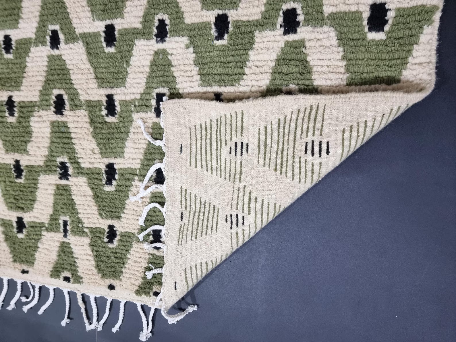 Green wool Beni Ourain rug featuring repeating geometric shapes