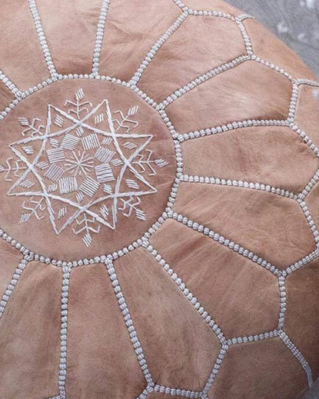 Hand stitched tan Moroccan pouf with white embroidery and artisan finish