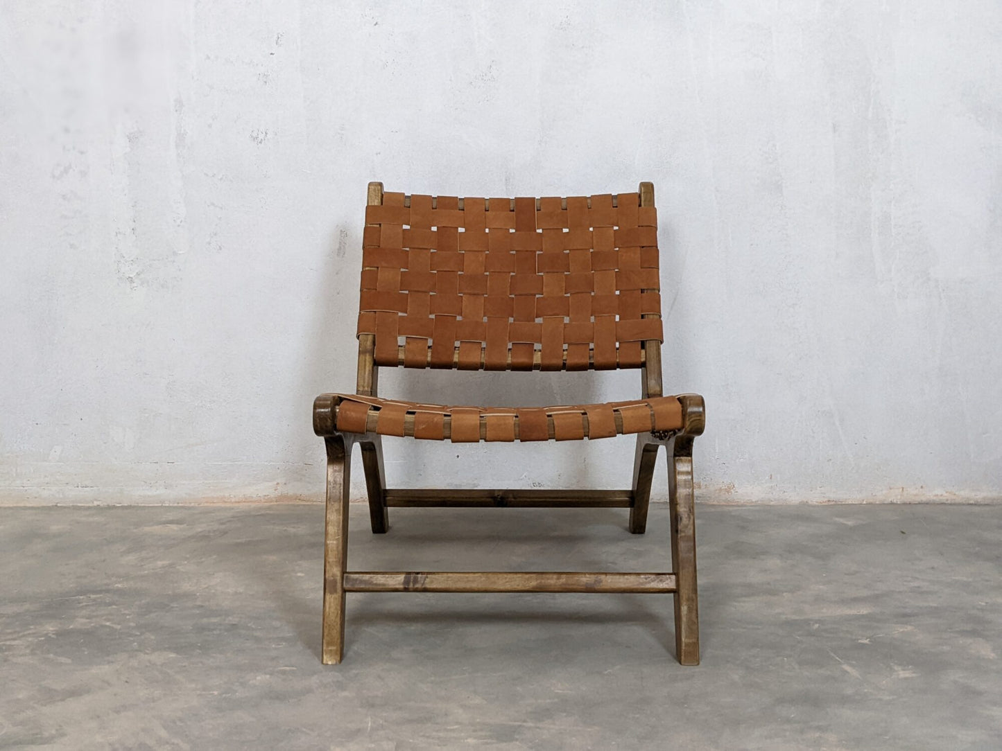 Handmade brown leather lounge chair with rustic wood frame and woven seat detail 
