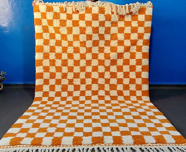 Handmade Moroccan checkered wool rug in orange and ivory with artisan Berber craftsmanship