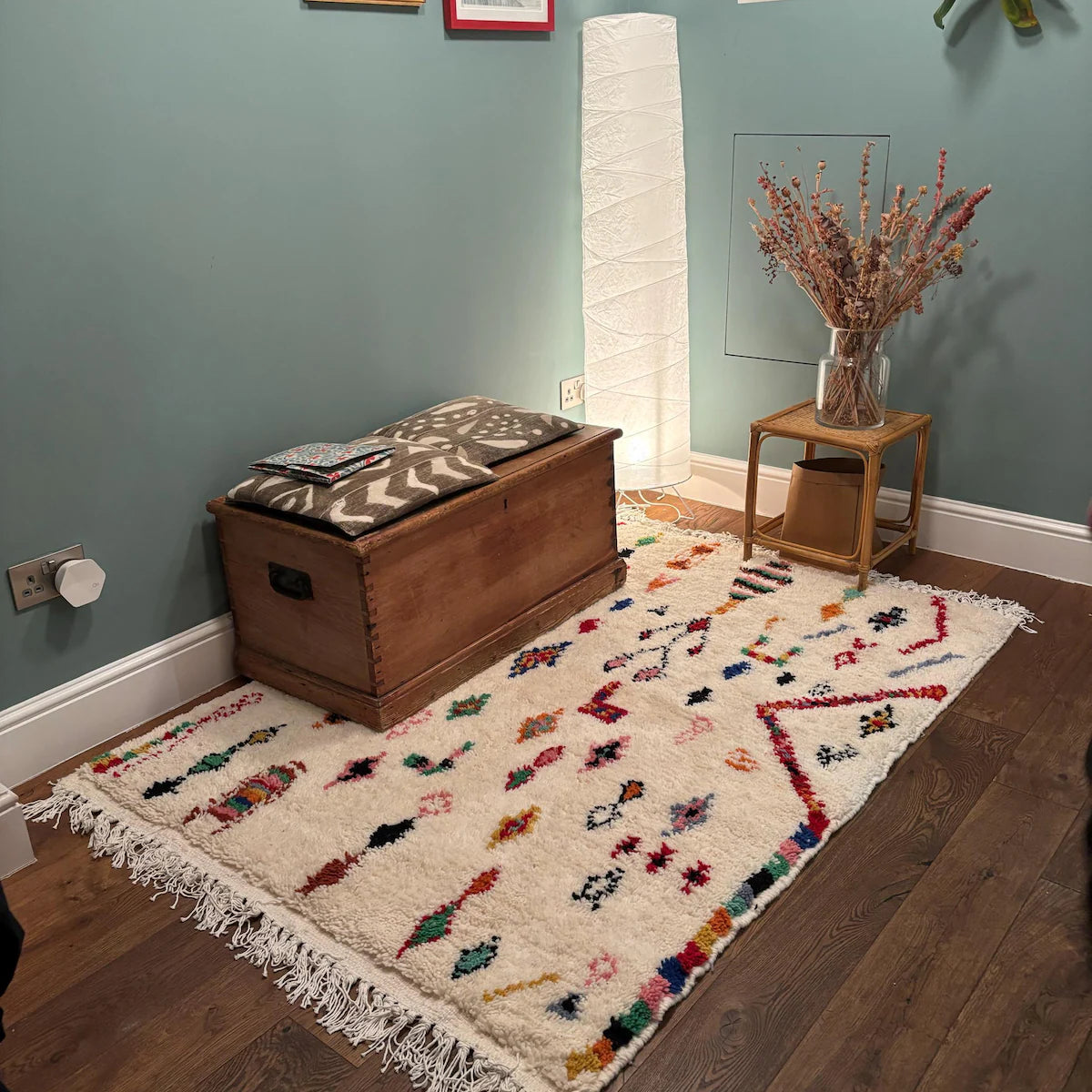 Handmade white Berber rug decorated with vibrant tribal and geometric details