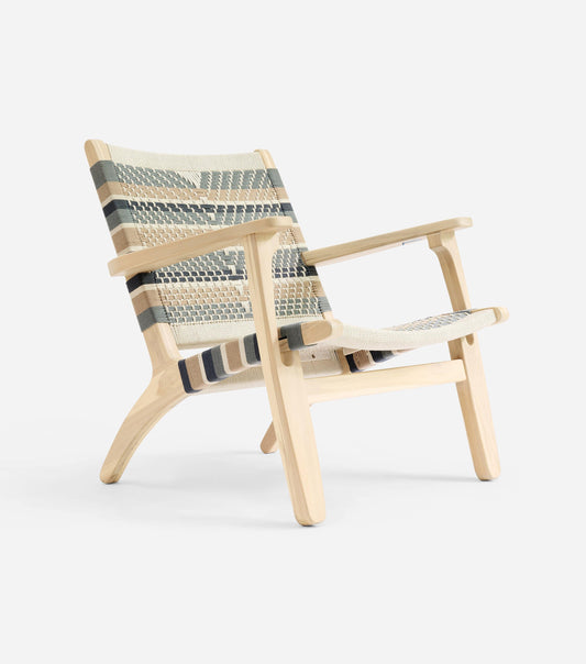 Handmade woven armchair with natural wood frame and soft neutral pattern 