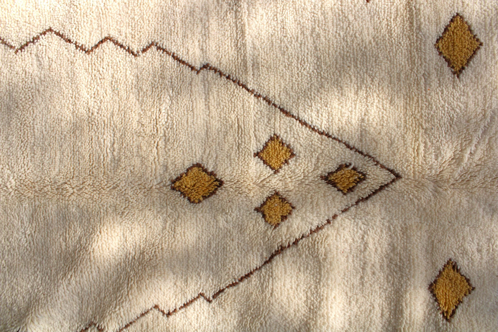 Handwoven ivory Moroccan wool rug with soft plush texture and artisan fringe