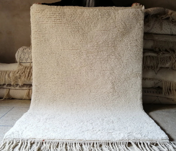 Natural white Beni Ourain wool rug with soft shag texture and fringe detail