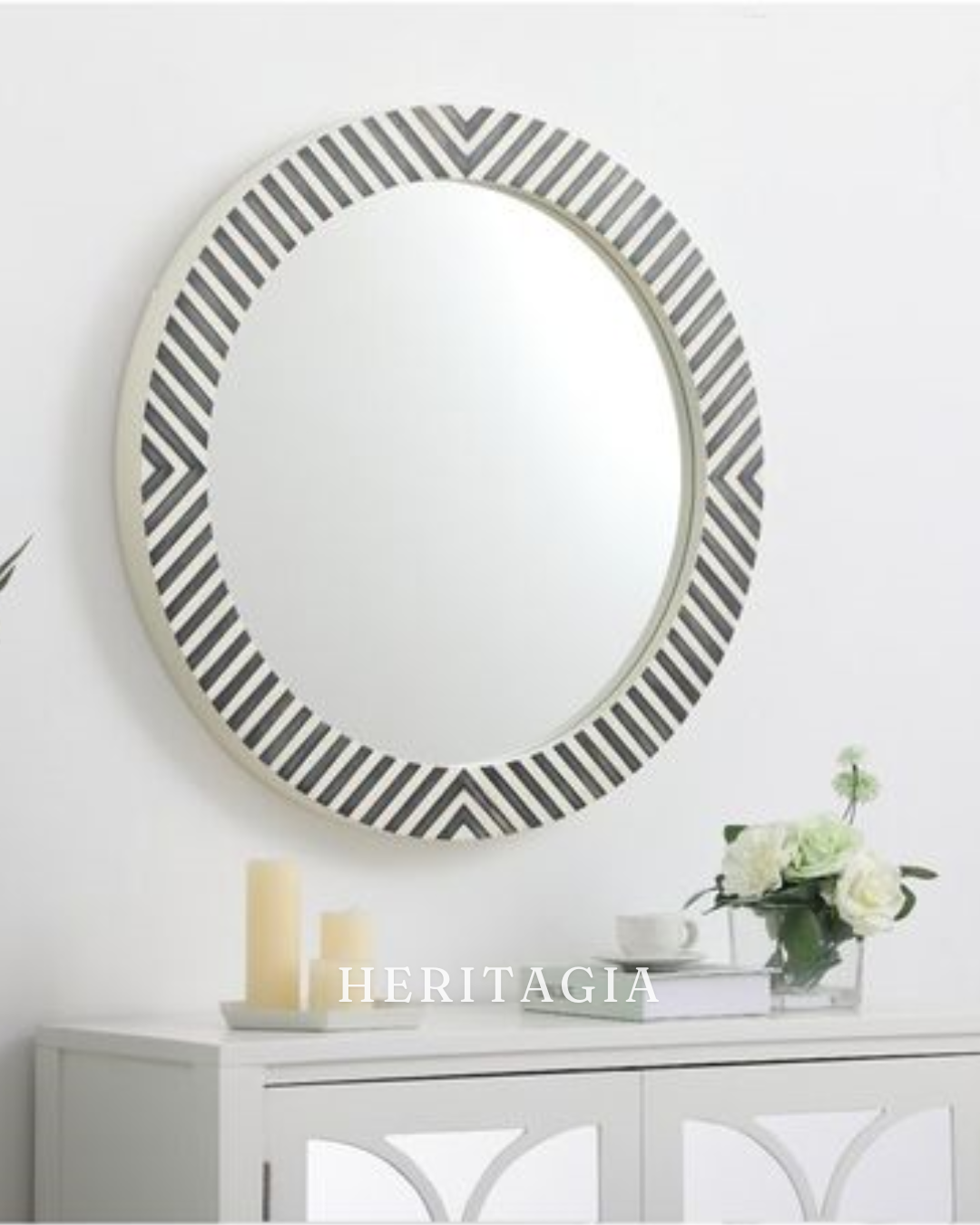 Round striped bone inlay mirror styled above a white console table 