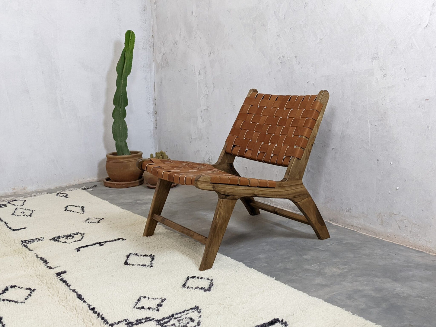 Rustic brown leather accent chair shown from the front with handwoven back and seat 