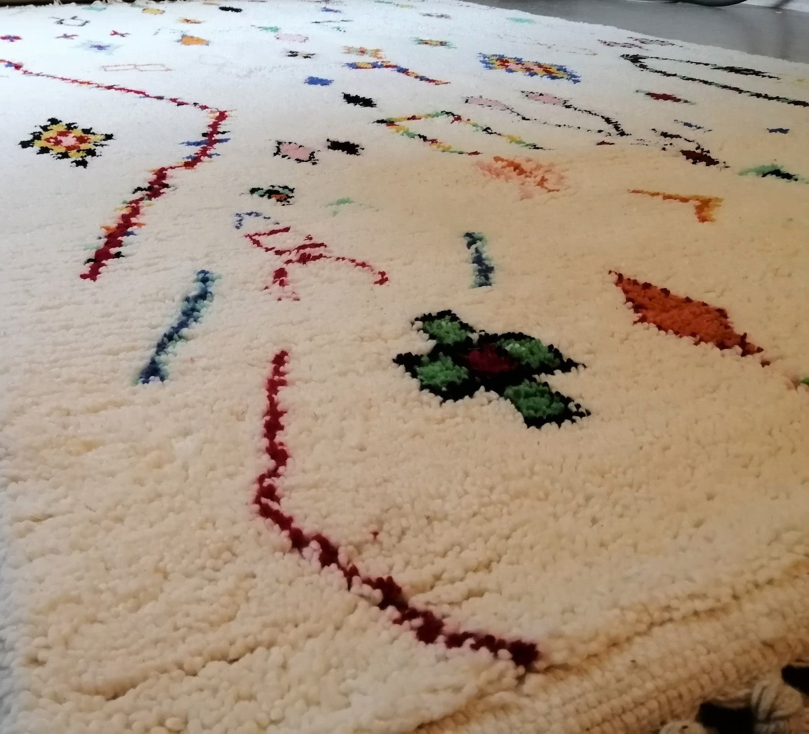 White Moroccan rug with colorful geometric pattern and handmade wool texture