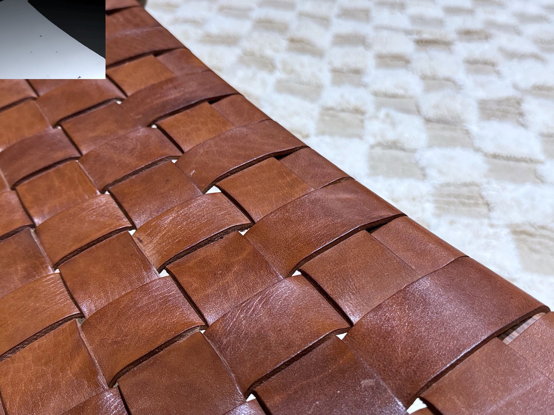 Artisan brown leather woven lounge chair styled in living room 